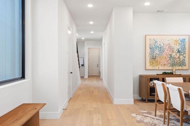 hall with light wood finished floors, visible vents, recessed lighting, and baseboards