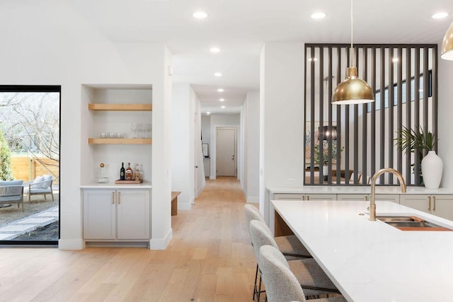 5514 Montview St, Austin, TX 78756 - hallway with a sink, light wood finished floors, recessed lighting, built in features, and baseboards
