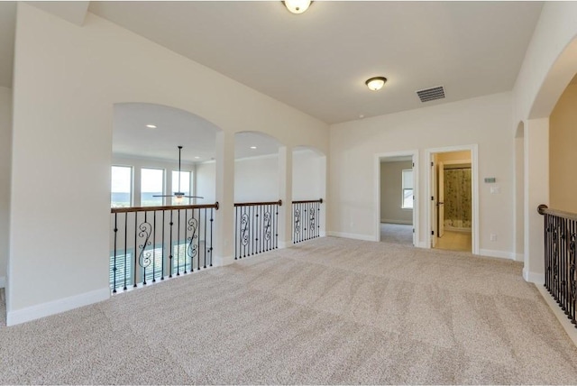 carpeted spare room with recessed lighting, visible vents, arched walkways, and baseboards