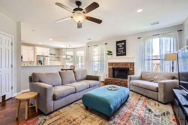 living room featuring visible vents, a healthy amount of sunlight, ceiling fan, and wood finished floors