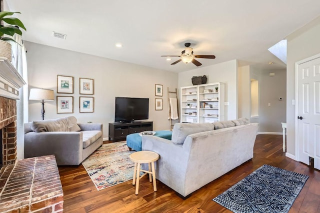 living area with dark wood-style floors, baseboards, ceiling fan, and a fireplace