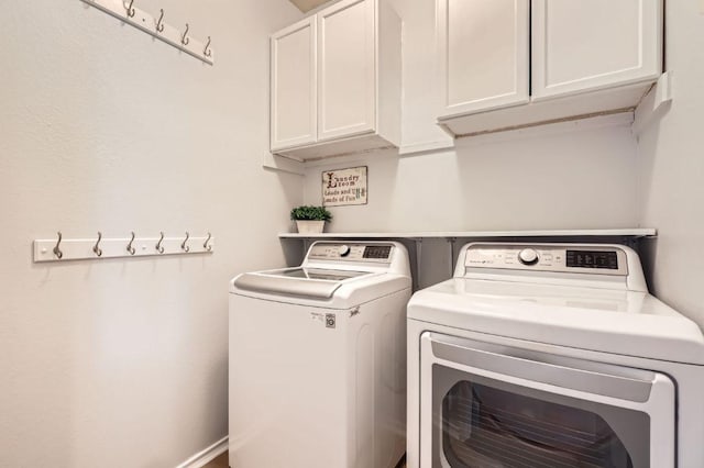 washroom with cabinet space and washer and dryer