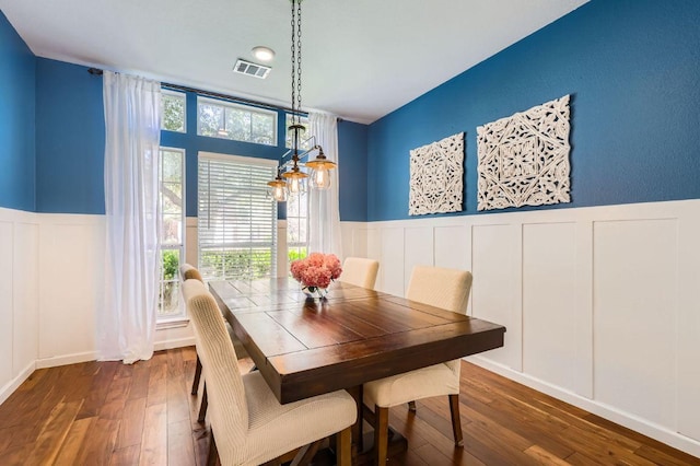 dining space featuring a wainscoted wall, dark wood-style floors, and visible vents