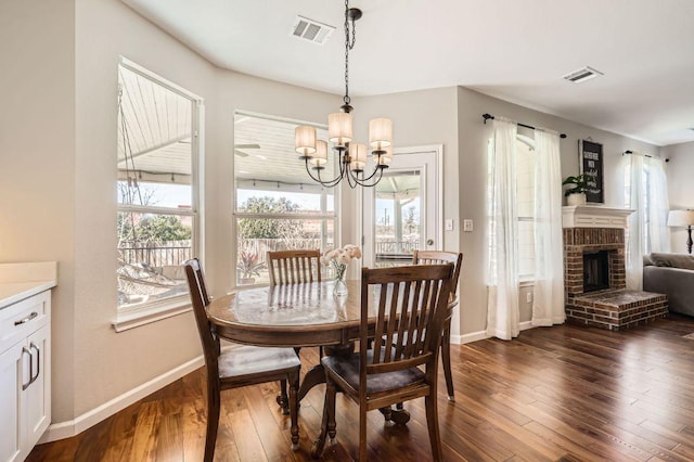 dining area featuring an inviting chandelier, visible vents, and dark wood-type flooring