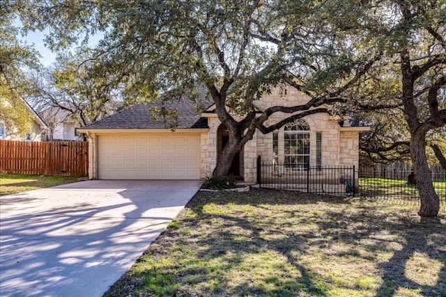 view of front facade featuring fence, a shingled roof, concrete driveway, a garage, and stone siding