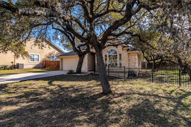 view of front of property featuring concrete driveway, central air condition unit, an attached garage, and fence