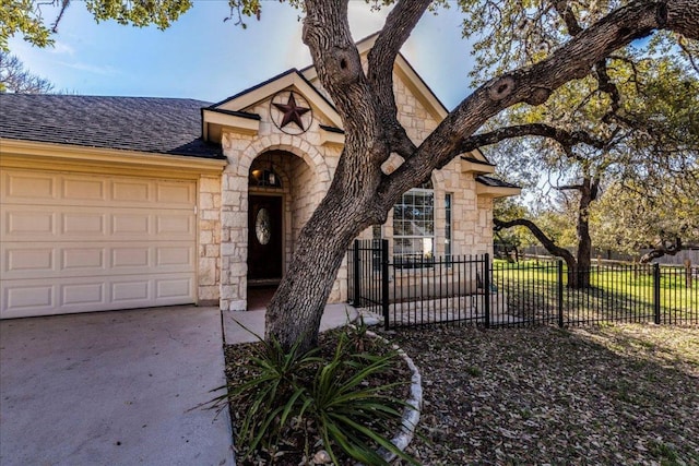 view of front of property with driveway, stone siding, fence, an attached garage, and a shingled roof