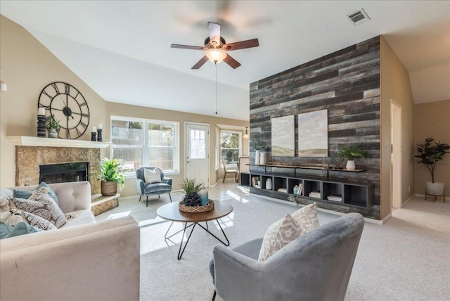 carpeted living room with a fireplace, lofted ceiling, a ceiling fan, and visible vents