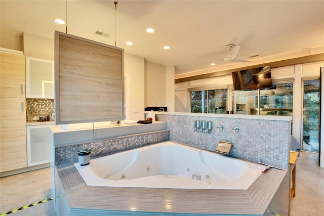 bathroom featuring tile patterned flooring, ceiling fan, a whirlpool tub, decorative backsplash, and recessed lighting