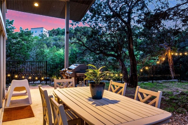 view of patio featuring area for grilling, outdoor dining area, and a fenced backyard