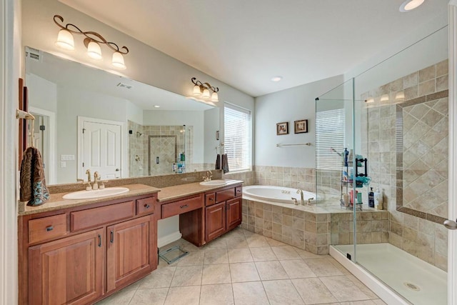 bathroom featuring tile patterned floors, a shower stall, a garden tub, and a sink