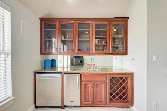 bar featuring a sink, baseboards, a healthy amount of sunlight, and vaulted ceiling