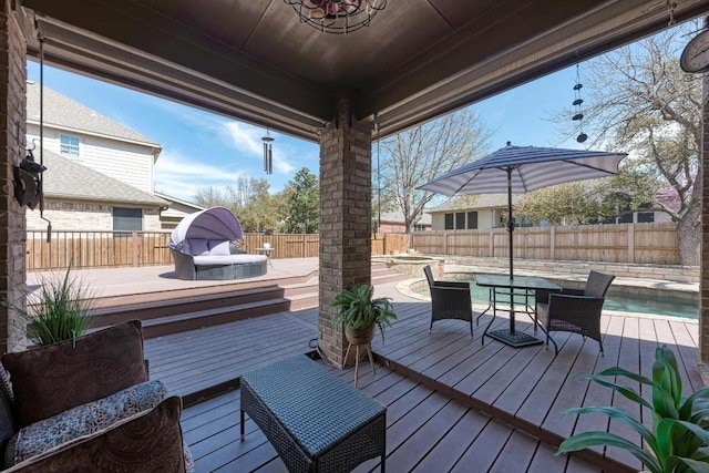 wooden deck with outdoor dining space and a fenced backyard