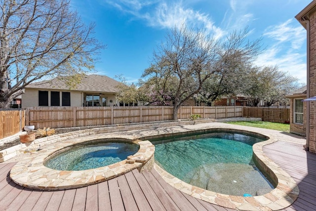 view of swimming pool featuring a deck, an in ground hot tub, and a fenced backyard