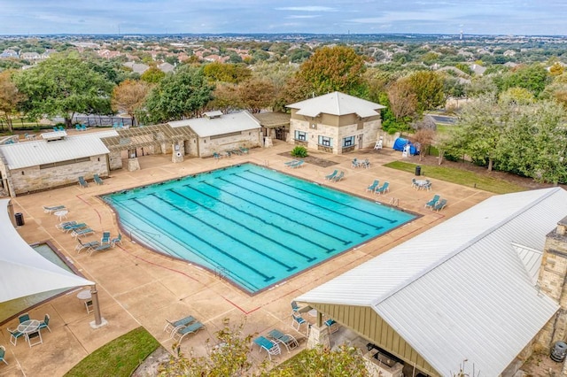 community pool with a patio area and fence