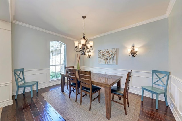 dining area featuring ornamental molding, a wainscoted wall, wood-type flooring, and a chandelier