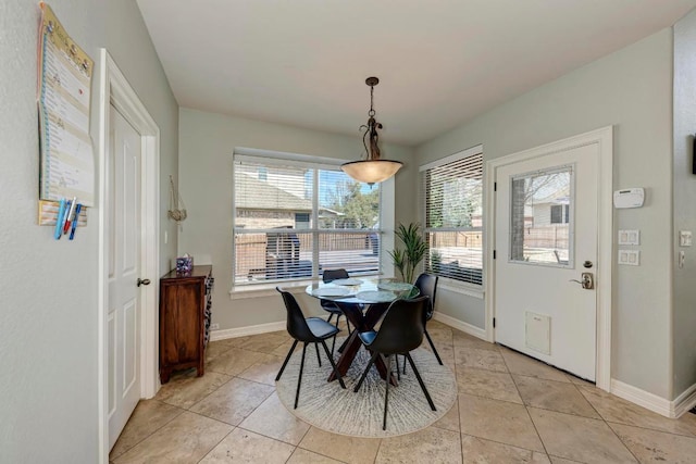 dining area featuring light tile patterned floors and baseboards