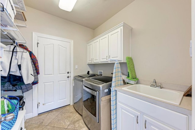 laundry room featuring washer and clothes dryer, light tile patterned floors, cabinet space, and a sink