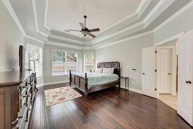 bedroom featuring wood finished floors, visible vents, baseboards, crown molding, and a raised ceiling