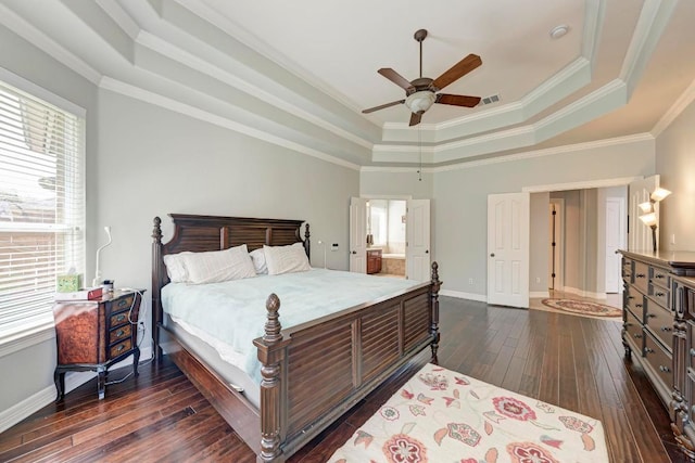 bedroom featuring dark wood-style floors, visible vents, baseboards, ornamental molding, and a raised ceiling