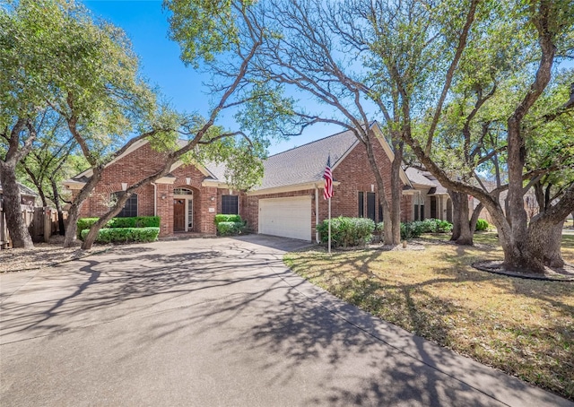 view of front of property with driveway, brick siding, roof with shingles, and an attached garage