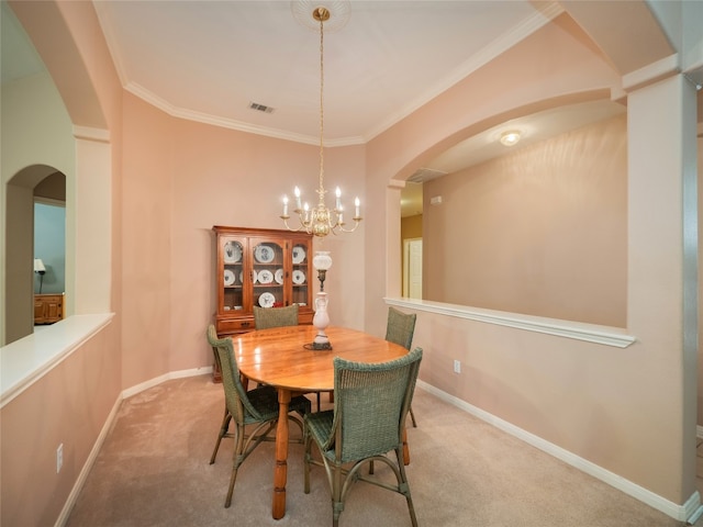 dining room featuring visible vents, baseboards, carpet, a chandelier, and ornamental molding