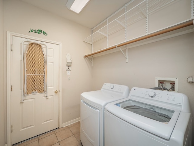 laundry room featuring baseboards, independent washer and dryer, light tile patterned flooring, and laundry area