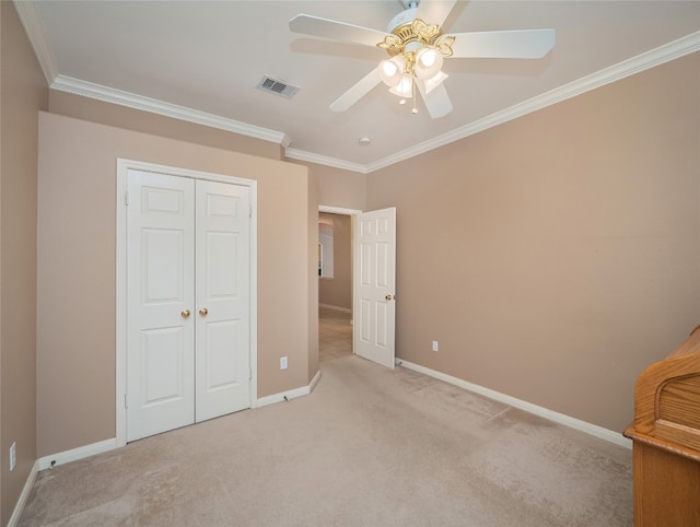 unfurnished bedroom with baseboards, visible vents, ornamental molding, a closet, and light carpet