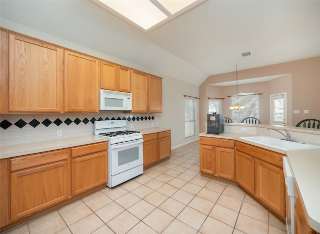 kitchen with white appliances, light tile patterned floors, visible vents, a sink, and backsplash