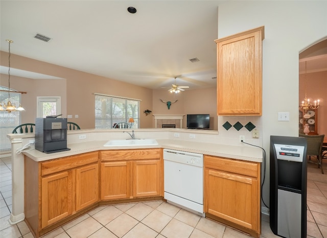 kitchen with a sink, ceiling fan with notable chandelier, a healthy amount of sunlight, and white dishwasher