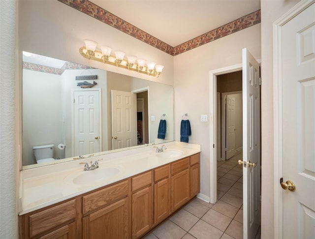 full bathroom featuring tile patterned floors, toilet, double vanity, and a sink