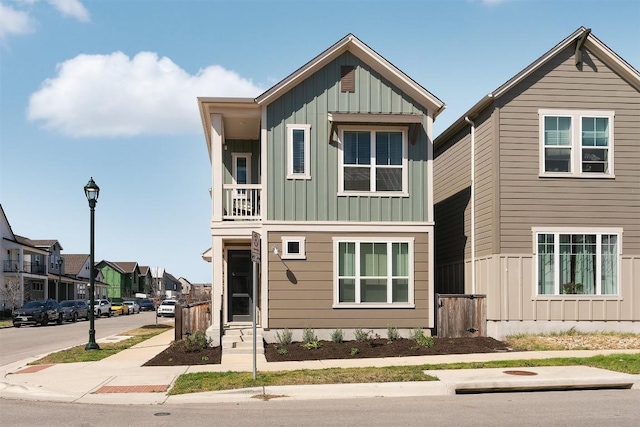 view of front of property with board and batten siding, a balcony, and a residential view