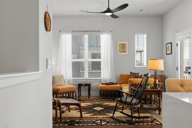 living area featuring visible vents, wood finished floors, and a ceiling fan