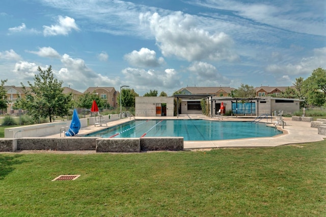 pool with a patio area, a lawn, and fence