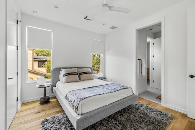 bedroom featuring visible vents, baseboards, light wood-style floors, and a ceiling fan