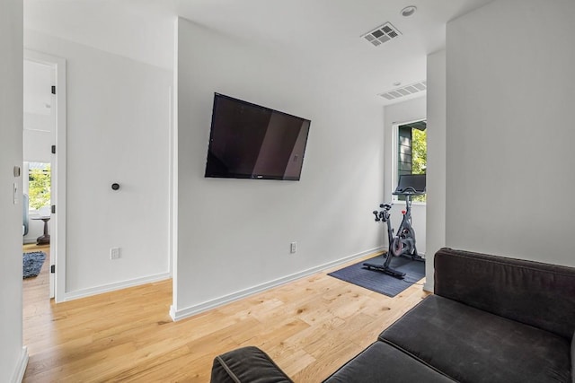 exercise area featuring wood finished floors, visible vents, and a wealth of natural light