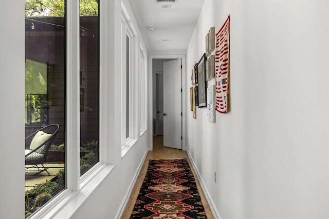 hall with visible vents and baseboards