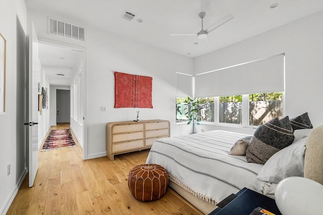 bedroom with visible vents, baseboards, a ceiling fan, and light wood finished floors