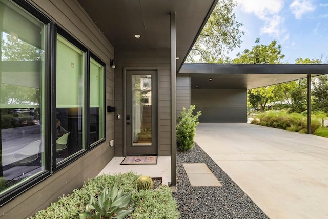 doorway to property with a carport and driveway