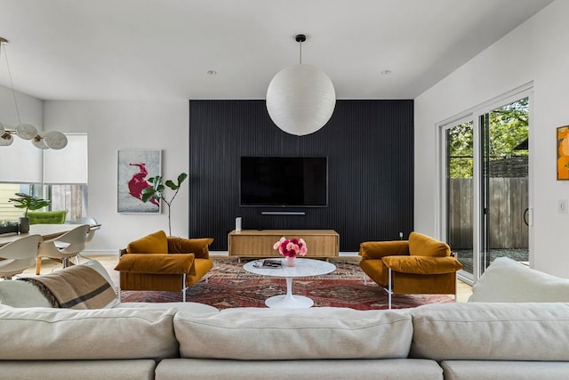 living room featuring baseboards and an accent wall