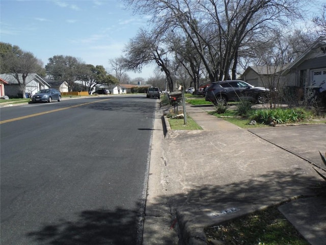 view of road with sidewalks, curbs, and a residential view