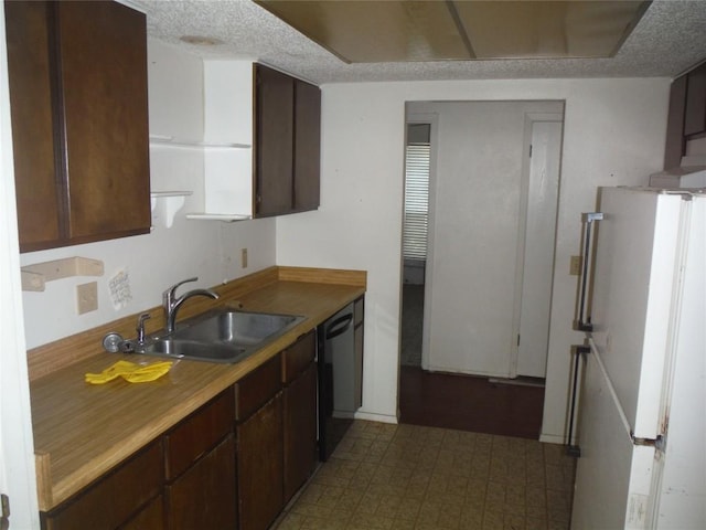 7729 Croftwood Dr, Austin, TX 78749 - kitchen with a sink, freestanding refrigerator, dishwasher, dark brown cabinets, and light countertops