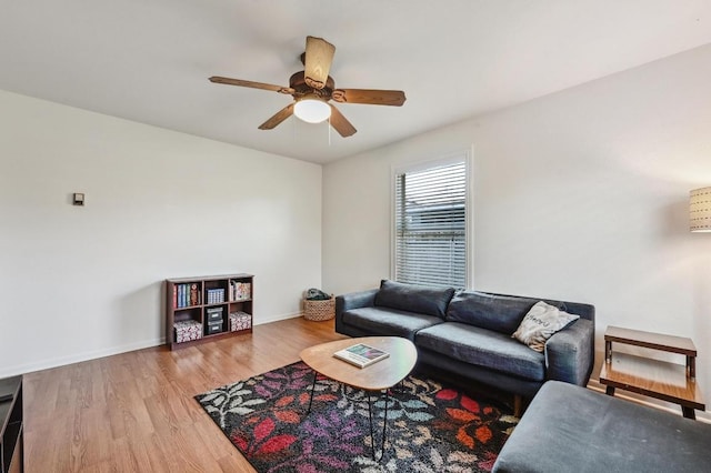 living room featuring wood finished floors, baseboards, and ceiling fan