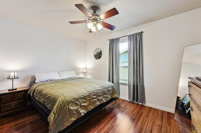 bedroom featuring baseboards, wood finished floors, and a ceiling fan