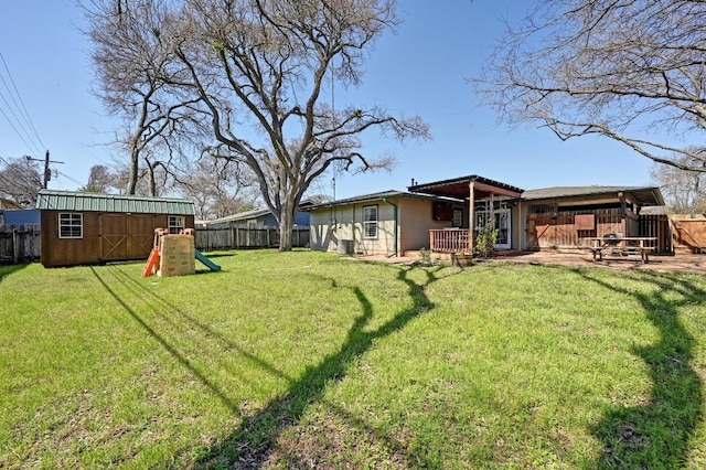 view of yard featuring an outbuilding, a fenced backyard, and a shed