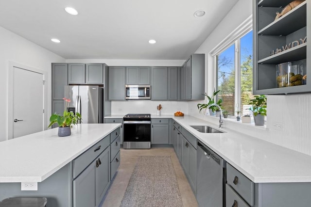 kitchen featuring recessed lighting, gray cabinets, appliances with stainless steel finishes, and a sink