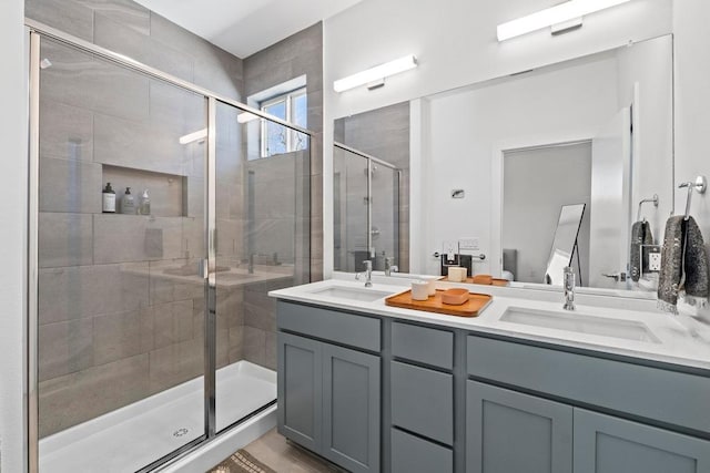 bathroom with a sink, double vanity, and a shower stall