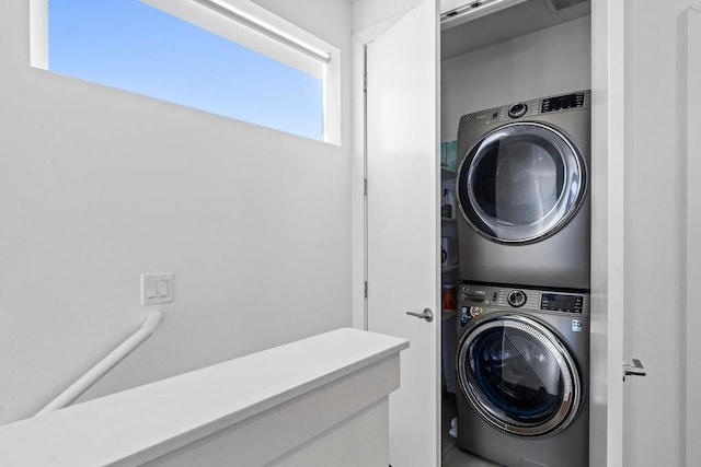 clothes washing area featuring visible vents, stacked washer and clothes dryer, and laundry area