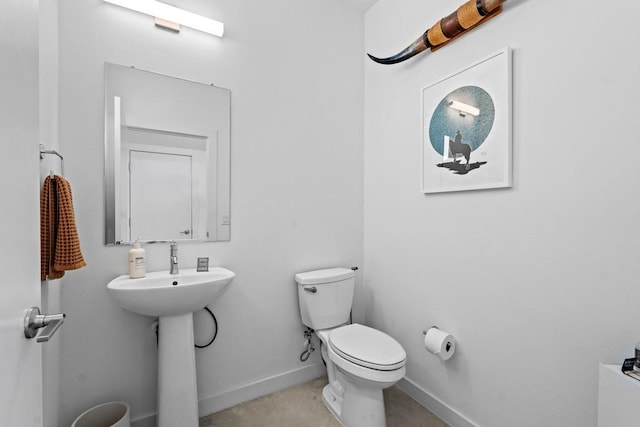 half bathroom featuring toilet and baseboards