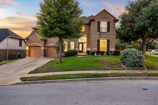 view of front of home featuring fence, an attached garage, concrete driveway, a front lawn, and brick siding